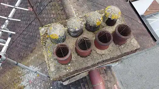 Chimney Pot Inspection and Cowl Fitting – London Close-up of terracotta chimney pots on a London rooftop