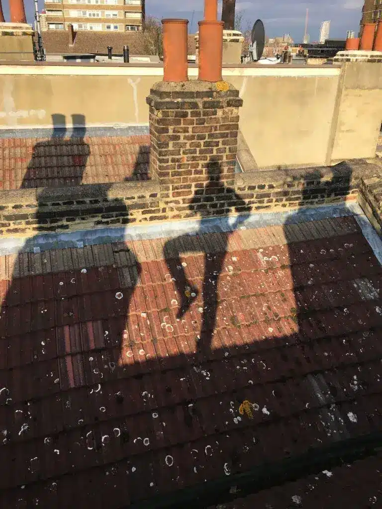 dancing-chimney-sweepsmart-london-essex-and-hertforshire Three SweepSmart chimney sweeps with brushes walking towards the entrance of BBC Broadcasting House in London